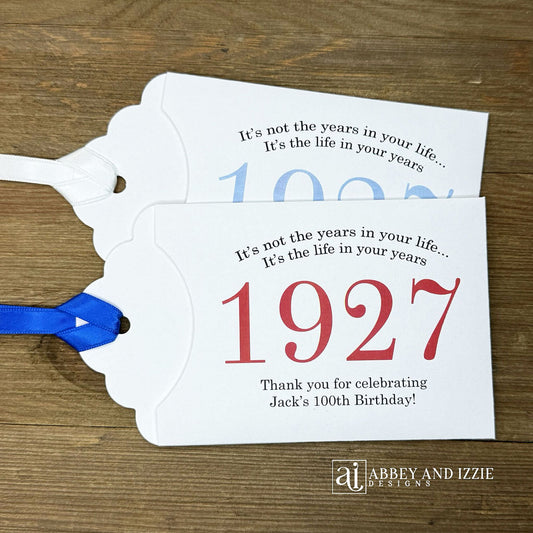 Our 100th birthday party favors are personalized for the guest of honor, your choice of ribbon color and year color. Always a fun ice breaker, slide a scratch off ticket in and see who is the winner! Each 100th birthday favor comes with the year the honoree was born printed in the center with 'It's not the years in your life...it's the life in your years' and happy birthday to the guest of honor. These can be made for any birthday year, 50th, 60th, 70th, 100th your choice. 100th Birthday Party Favors