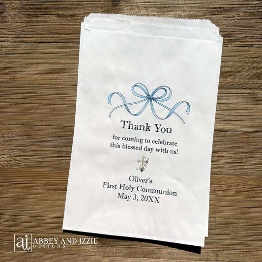Celebrate your son's First Communion with our personalized First Communion Favor Bags that transform a sacred moment into a cherished memory. Each bag is customized with his name, event date and a sweet thank you. Printed on white bags with a fun blue bow and a cross.