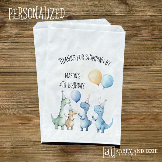 Thanks for Stompling By! Our dinosaur treat bags are sure to be a hit, adorned with cute dinosuars with hats and balloons to celebrate the honoree. Personalized with the childs name and birthday year. Printed on white bags these are colorful and fun!