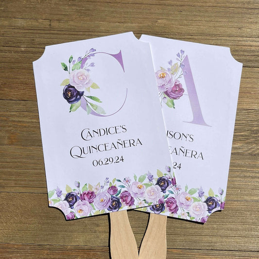 Personalized Quinceanera Favor Fans, Printed on white card stock, purple flowers adorn the bottom with a large floral monogram. Perfect to keep your guests cool and comortable with a keep sake to take home.