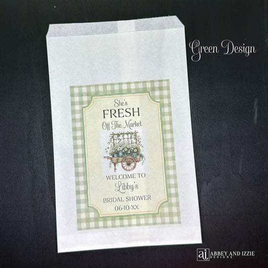 Our "Fresh Off The Market" bridal shower bags are the perfect keepsake for guests—ideal for holding treats, small gifts, or personalized tokens of appreciation. Printed on white bags with your choice of blue or green flower carts. Personalized with the brides name and shower date.