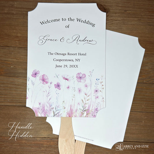 Blush pink wedding fans personalized, printed on white card stock with soft pink flower at the bottom. Fans are personalized for the bride and groom and includes, place, city, state and date of your wedding. They arrive fully assembled and ready for your day.