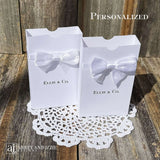 White favor boxes for any occasion personalized.  Made from white card stock with white ribbon around the box and a white satin bow attached.
