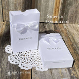 White favor boxes for any occasion personalized.  Made from white card stock with white ribbon around the box and a white satin bow attached.