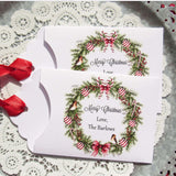 Personalized Christmas Party Favors adorned with a beautiful wreath and a red ribbon attached.  These can be used for lottery ticket favors or gift card holders.