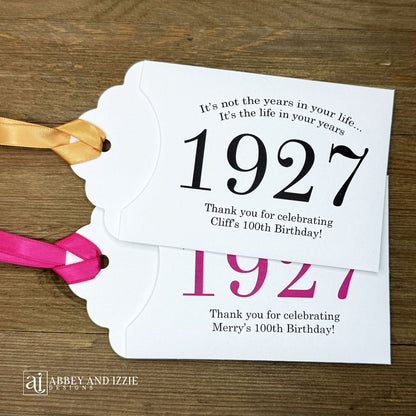 Our 100th birthday party favors are personalized for the guest of honor, your choice of ribbon color and year color. Always a fun ice breaker, slide a scratch off ticket in and see who is the winner! Each 100th birthday favor comes with the year the honoree was born printed in the center with 'It's not the years in your life...it's the life in your years' and happy birthday to the guest of honor. These can be made for any birthday year, 50th, 60th, 70th, 100th your choice. 100th Birthday Party Favors