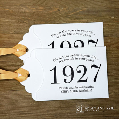 Our 100th birthday party favors are personalized for the guest of honor, your choice of ribbon color and year color. Always a fun ice breaker, slide a scratch off ticket in and see who is the winner! Each 100th birthday favor comes with the year the honoree was born printed in the center with 'It's not the years in your life...it's the life in your years' and happy birthday to the guest of honor. These can be made for any birthday year, 50th, 60th, 70th, 100th your choice. 100th Birthday Party Favors