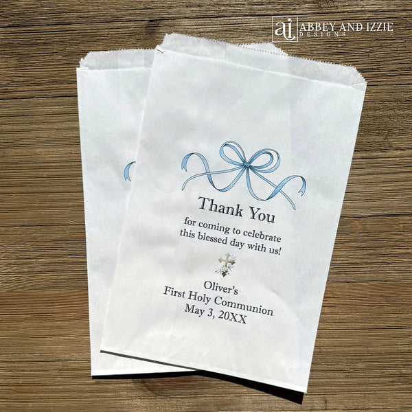Celebrate your son's First Communion with our personalized First Communion Favor Bags that transform a sacred moment into a cherished memory. Each bag is customized with his name, event date and a sweet thank you.  Printed on white bags with a fun blue bow and a cross.