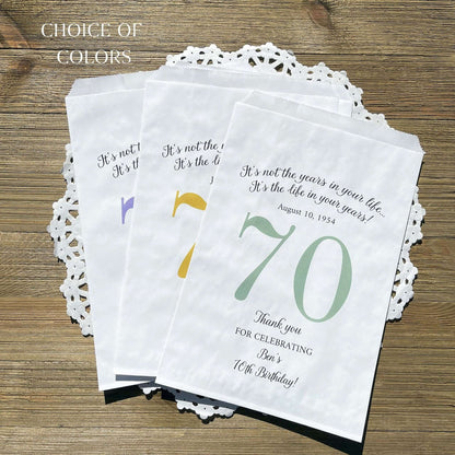Personalized 70th Birthday Favor Bags, fill them with sweet treats for your guests.  White paper bags printed with a large # 70 and personalized for the guest of honor.  Larger favor bags to hold more treats.  Adult part favor bags that also great for holding a napkin and utensils.