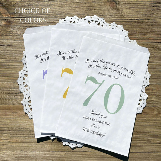 Personalized 70th Birthday Favor Bags, fill them with sweet treats for your guests.  White paper bags printed with a large # 70 and personalized for the guest of honor.  Larger favor bags to hold more treats.  Adult part favor bags that also great for holding a napkin and utensils.