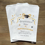 Graduation favor bags, personalized with  the guest of honors name and event date.  Adorned with a gold ribbon, gold and black stars and black graduation cap.  Bags can be used for sweet treats, take home thank you gift, cookies, candy or perfect for utenisl bags.  