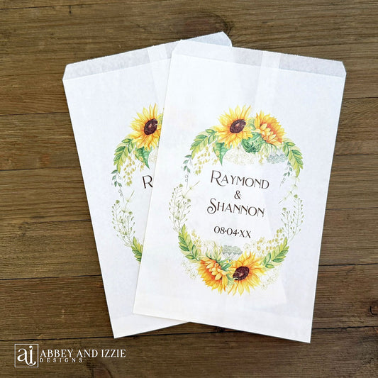 Sunflower Wedding Favor Bags that are personalized for the bride and groom.  Adorned with a sunflower wreath around the names and wedding date.  