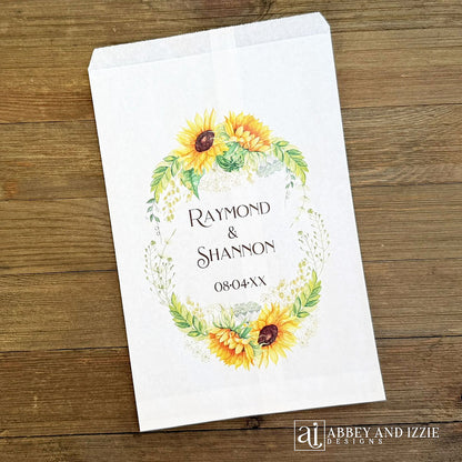 Sunflower Wedding Favor Bags that are personalized for the bride and groom.  Adorned with a sunflower wreath around the names and wedding date.  