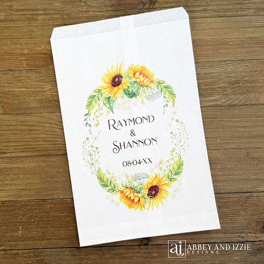 Sunflower Wedding Favor Bags that are personalized for the bride and groom.  Adorned with a sunflower wreath around the names and wedding date.  
