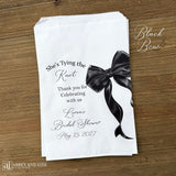 Send your guests home with a memorable keepsake from the bride-to-be's special day with our She's Tying the Knot Bridal Shower Favor Bags . These charming favor bags feature a playful "She's Tying the Knot" design that perfectly captures the excitement of bridal shower celebrations.  Adorned with a black or Pink bow, your choice and personalized for the bride to be.  Printed on white bags, larger than most.