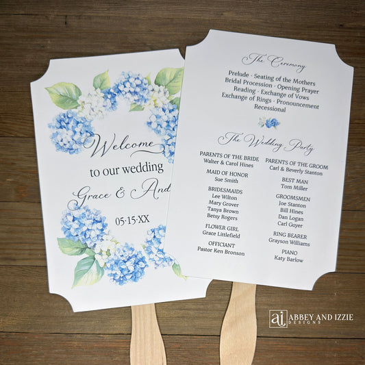 Elevate your wedding ambiance with our personalized blue hydrangea program fans, beautifully crafted to complement your special day.  Printed on white card stock with 'welcome to our wedding' and the bride and grooms names with wedding date printed. 