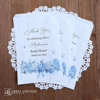 Personalized blue hydrangea bridal shower favors bags, perfect for a small gift of appreciation or a cookie bar or even a candy bar.  White bags adorned with delicate blue hydrangeas for a sweet addition to your event.