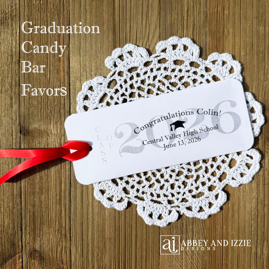 Graduation Candy Bar Favors personalized for the graduate. Printed on white card stock, choice of ribbon color.  Class of year printed in large font and congratulations to the guest of honor with school name and event date.  Just slide a candy bar in the open end and tie the ribbon on.