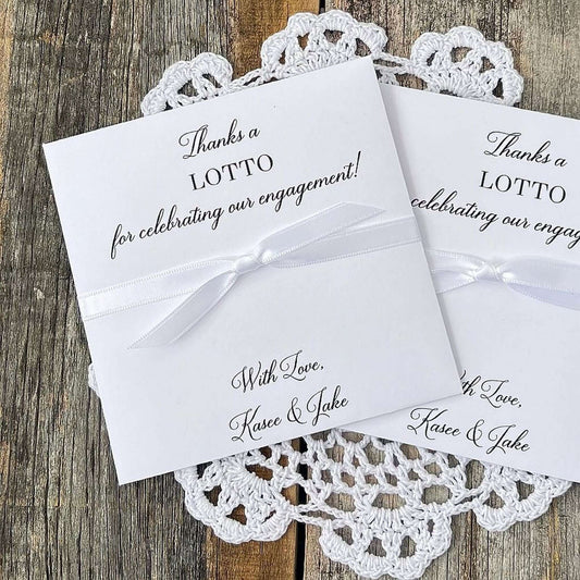 Personalized engagement party favors, slide a lotto ticket in these envelopes to see who wins.  Printed with, thanks a lotto for celebrating our engagement!  with love the happy couple.  White envelopes, your choice of ribbon color which comes attached