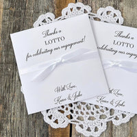 Personalized engagement party favors, slide a lotto ticket in these envelopes to see who wins.  Printed with, thanks a lotto for celebrating our engagement!  with love the happy couple.  White envelopes, your choice of ribbon color which comes attached