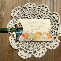 Ivory lottery ticket envelopes for a fall wedding, personalized for the bride and groom.  Each comes with moss green or gold ribbon attached, adorned with a fall scene.  Slide a lottery ticket in to see who wins.