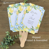 Mediterraanean wedding program fans, adorned with blue tiles and lemons.  Printed on white card stock, two sided with handle hidden between.  Wedding program on the back on the fans, front is personalized for the bride and groom.