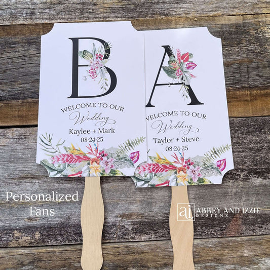 tropical themed wedding fans monogrammed  that are personalized with your large initial, bride and grooms names and wedding date. Adorned with tropical flowers, printed on white card stock. A great keepsake to take home as well as keeping your guests comfortable. Perfect for destination weddings.