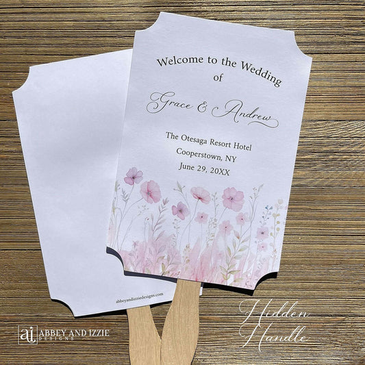 Blush pink wedding fans personalized, printed on white card stock with soft pink flower at the bottom.  Fans are personalized for the bride and groom and includes, place, city, state and date of your wedding.  They arrive fully assembled and ready for your day.