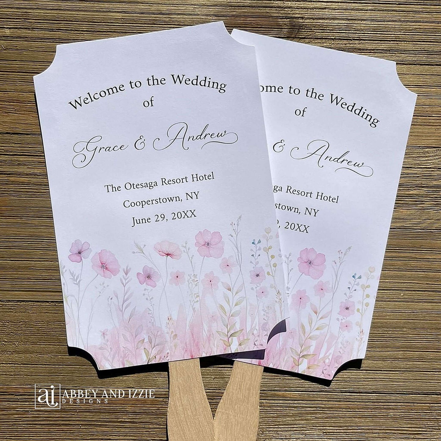 Blush pink wedding fans personalized, printed on white card stock with soft pink flower at the bottom.  Fans are personalized for the bride and groom and includes, place, city, state and date of your wedding.  They arrive fully assembled and ready for your day.
