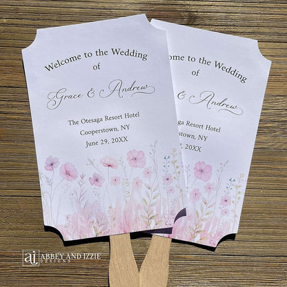 Blush pink wedding fans personalized, printed on white card stock with soft pink flower at the bottom.  Fans are personalized for the bride and groom and includes, place, city, state and date of your wedding.  They arrive fully assembled and ready for your day.