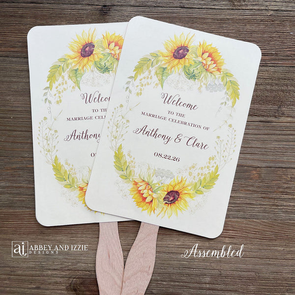 Sunflower wedding fans , personalized for the bride and groom and adorned with a ring of sunflowers.  Fans are printed on ivory cardstock, two sided so handle is hidden between.  Wedding fans ship fully assembled and ready for your big day.