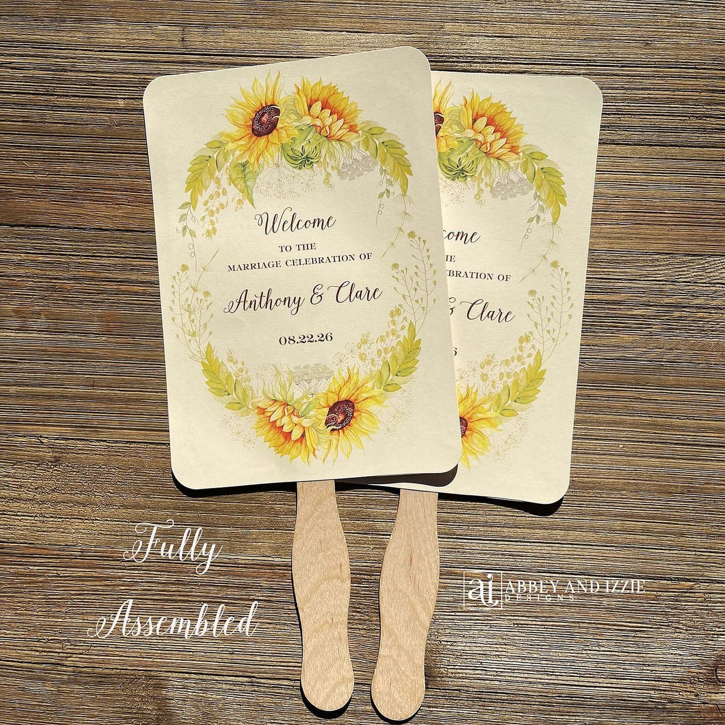 Sunflower Wedding Hand Fans Personalized , personalized for the bride and groom and adorned with a ring of sunflowers.  Fans are printed on ivory cardstock, two sided so handle is hidden between.  Wedding fans ship fully assembled and ready for your big day.