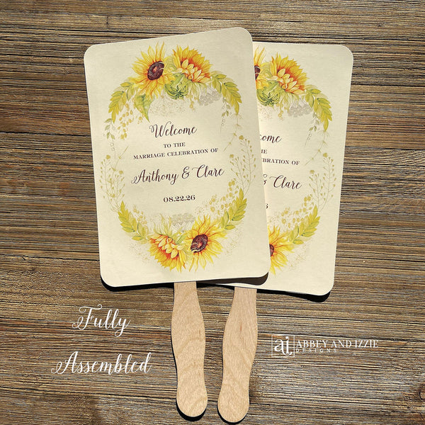 Sunflower wedding fans , personalized for the bride and groom and adorned with a ring of sunflowers.  Fans are printed on ivory cardstock, two sided so handle is hidden between.  Wedding fans ship fully assembled and ready for your big day.