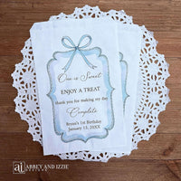 Personalized first birthday party favor bags, 'one is sweet, enjoy a treat, thank you for making my day complete'.  Printed on white paper bags and adorneed with a blue bow and border these will add a touch of elegance to the treat table. 
