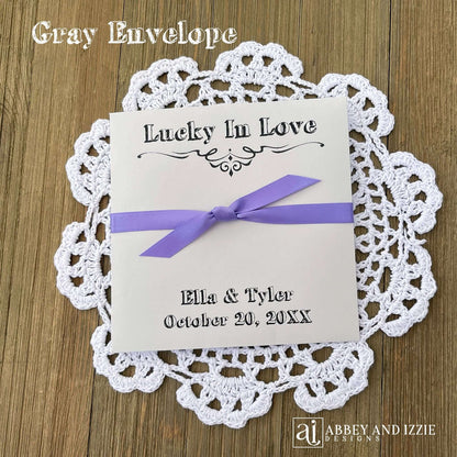 Rustic Wedding Guest Favors, printed with 'Lucky In Love' and the bride and groom with wedding date. Large envelopes, easy to add a scratch off lotto ticket for a fun favor. Your choice of envelope and ribbon color.