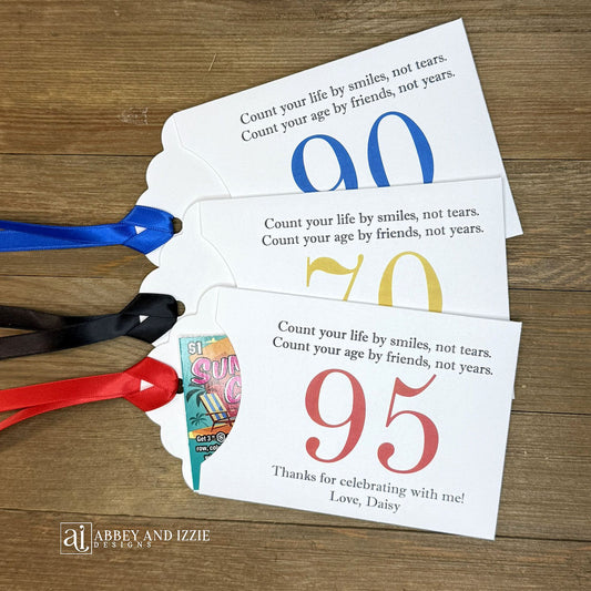 Celebrate with milestone birthday party guest favors that they will treasure. Each favor is customized with names, dates and a special messages to make your event unforgettable. Perfect for 30th, 40th, 50th, and beyond—these keepsakes add a personal touch to any milestone celebration.&nbsp; &nbsp;Printed on white cardstock with your choice of large number and ribbon color to match your party theme.&nbsp;