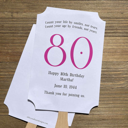 Milestone Birthday Party Favor Fans, keep your guests cool with our fans, perfect keepsake to take home from the party.  Adorned with the large birthday number with the name and birth date of the guest of honor.  Printed on white card stock with your choice of color number.