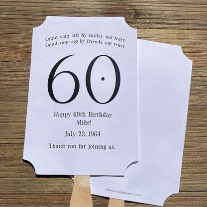 Milestone Birthday Party Favor Fans, keep your guests cool with our fans, perfect keepsake to take home from the party.  Adorned with the large birthday number with the name and birth date of the guest of honor.  Printed on white card stock with your choice of color number.