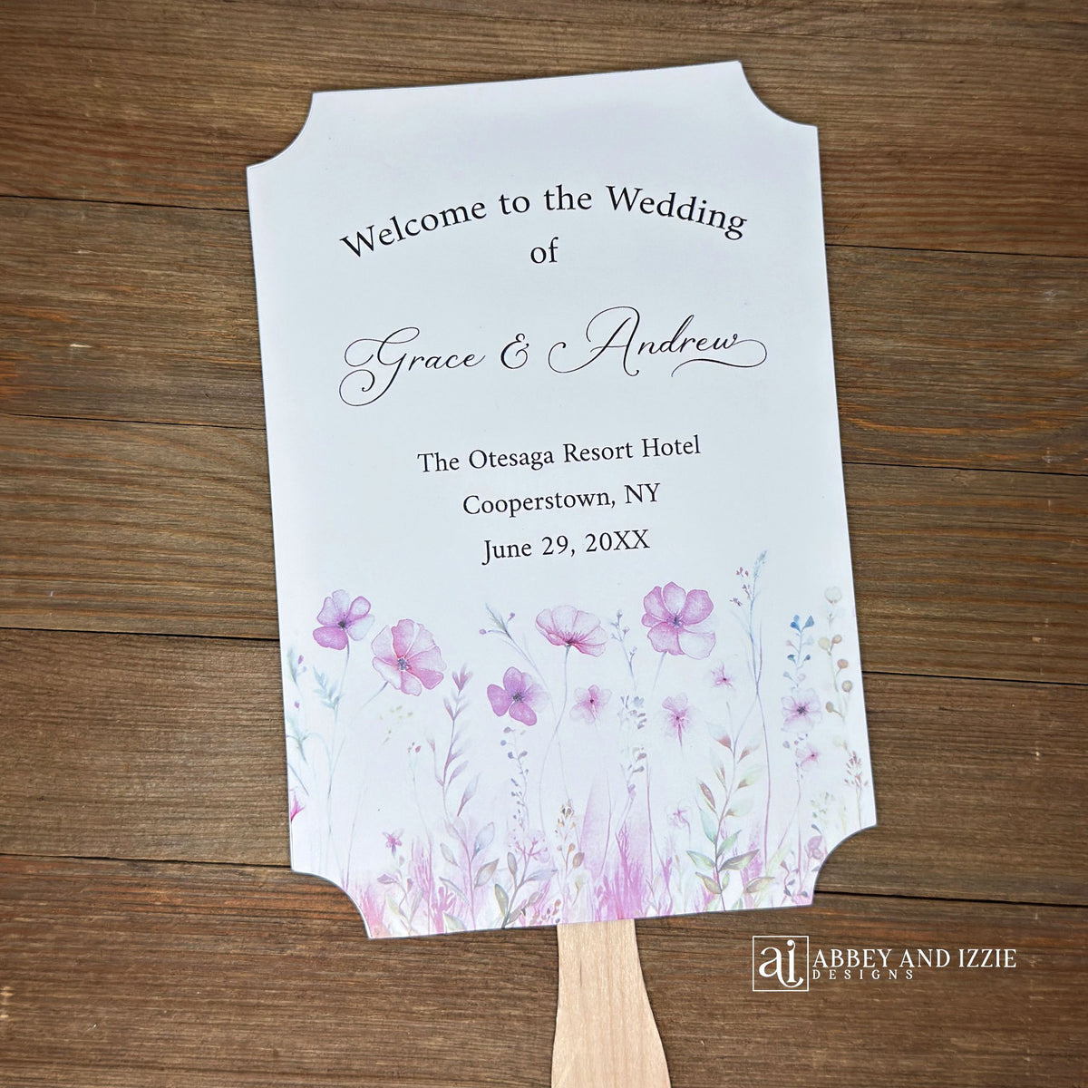 Blush pink wedding fans personalized, printed on white card stock with soft pink flower at the bottom.  Fans are personalized for the bride and groom and includes, place, city, state and date of your wedding.  They arrive fully assembled and ready for your day.