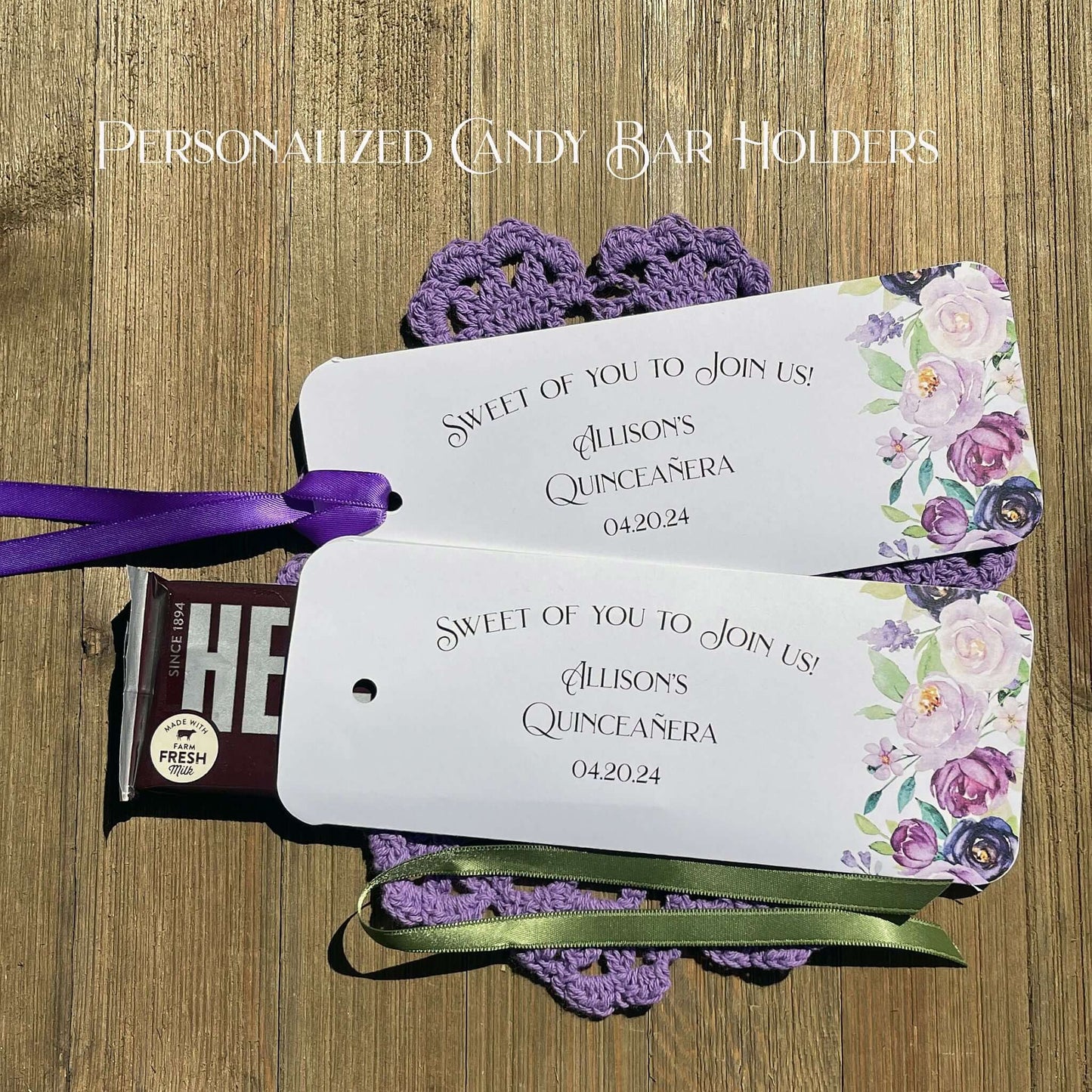 Personalized Quinceanera Candy Favors printed on white card stock and adonred with purple flowers.  Each printed with 'sweet of you to join us' with the guest of honors name and event date.  Slide a candy bar in the open end and tie the ribbon on, your choice of purple or moss green ribbon.