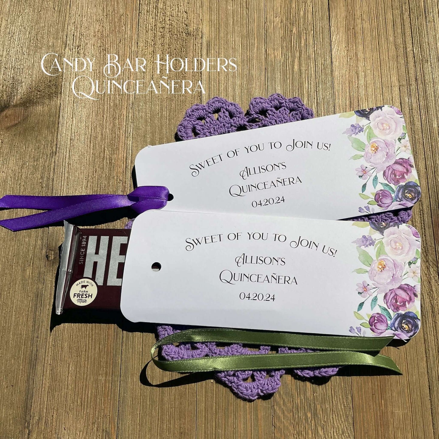 Personalized Quinceanera Candy Favors printed on white card stock and adonred with purple flowers.  Each printed with 'sweet of you to join us' with the guest of honors name and event date.  Slide a candy bar in the open end and tie the ribbon on, your choice of purple or moss green ribbon.