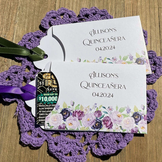 Purple Quninceanera Favors Personalized, slide a scratch off lotto ticket in the envelope and see who wins big.  Envelopes are white adorned with purple flowers and personalized for the guest of honor.  Purple or moss green ribbon comes attached.