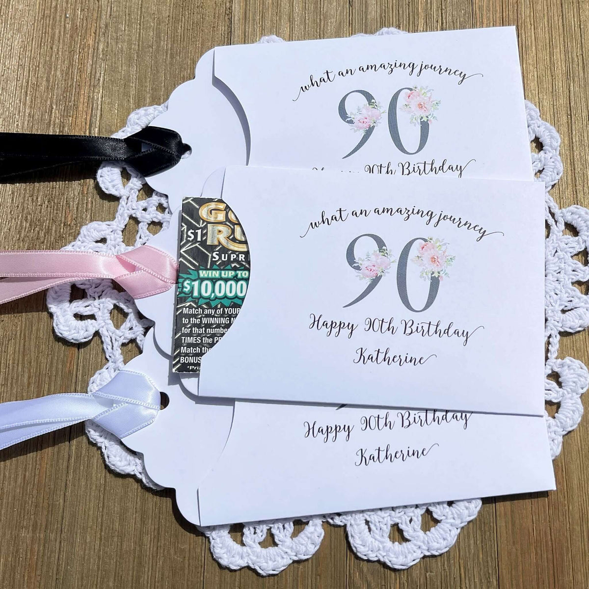 Elegant 90th Birthday Party Favors will add a special touch to your event.  Printed on white card stock with a large 90 in floral font add the guest of honors name for a personal touch.  Your choice of pink, black or white ribbon which comes attahced.