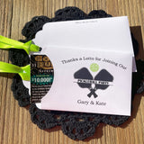 Pickleball party favors that will be fun for all your guests. Adonred with a pickleball and paddles these are personalized for the event. Printed on white cardstock with green ribbon attached. Slide a lottery ticket in the open end and see who wins.