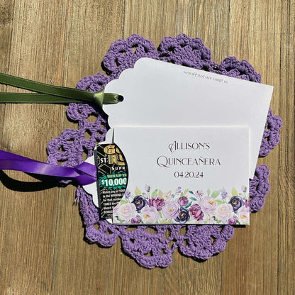 Purple Quninceanera Favors Personalized, slide a scratch off lotto ticket in the envelope and see who wins big.  Envelopes are white adorned with purple flowers and personalized for the guest of honor.  Purple or moss green ribbon comes attached.