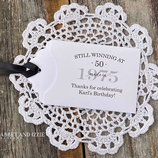 Lottery Ticket Birthday Favors, slide a lottery ticket in these cute envelopes for a fun favor.  Printed with 'still winning at' with your birthday number and year.  Printed on white card stock with your choice of ribbon color.