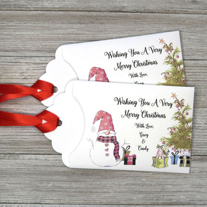 Small Christmas gift lottery ticket envelopes, give your guests a chance to win big. Enclose a scratch off lotto ticket, just a little something to remember friends or co-workers this Holiday Season.  Envelopes are made from white cardstock with a snowman, Christmas tree and gifts.  Personalized with wishing you a Very Merry Christmas. Red ribbon comes attached.