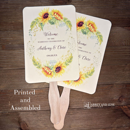 Sunflower Wedding Hand Fans Personalized , personalized for the bride and groom and adorned with a ring of sunflowers.  Fans are printed on ivory or white cardstock, two sided so handle is hidden between.  Wedding fans ship fully assembled and ready for your big day.