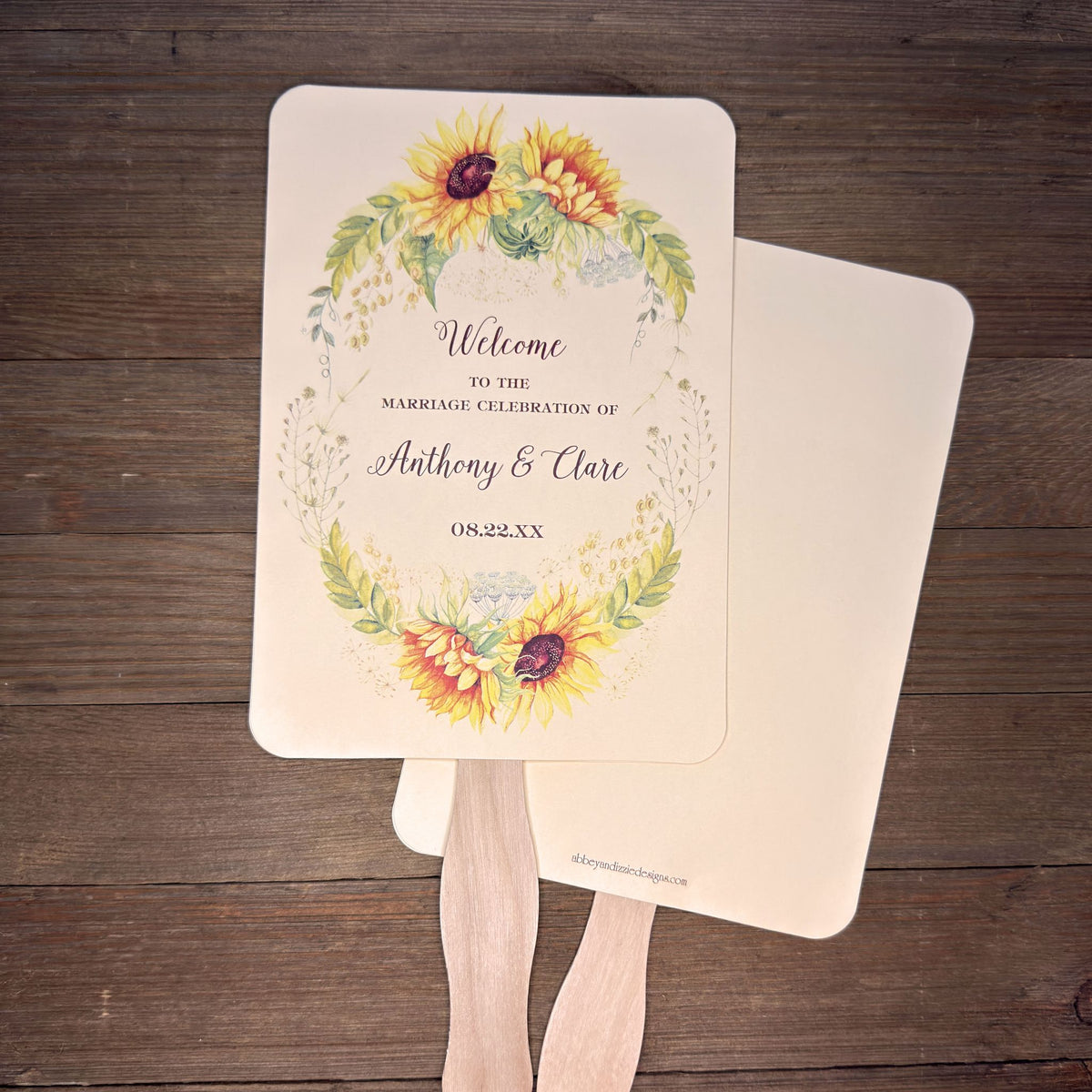 Sunflower Wedding Hand Fans Personalized , personalized for the bride and groom and adorned with a ring of sunflowers.  Fans are printed on ivory or white cardstock, two sided so handle is hidden between.  Wedding fans ship fully assembled and ready for your big day.