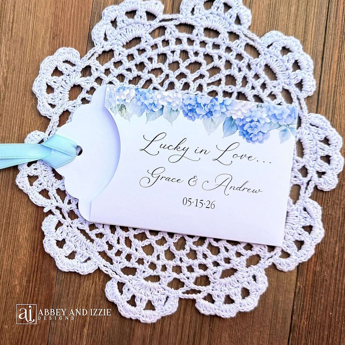 Our blue hydrangea wedding favors are made from white cardstock, adorned with delicate hydrangeas at the top, printed with 'Lucky In Love' with the brdie and grooms names and wedding date.  Each comes with a light blue ribbon attached for an elegant touch.  Guest will find these lotto favors fun with hopes of winning something big.  